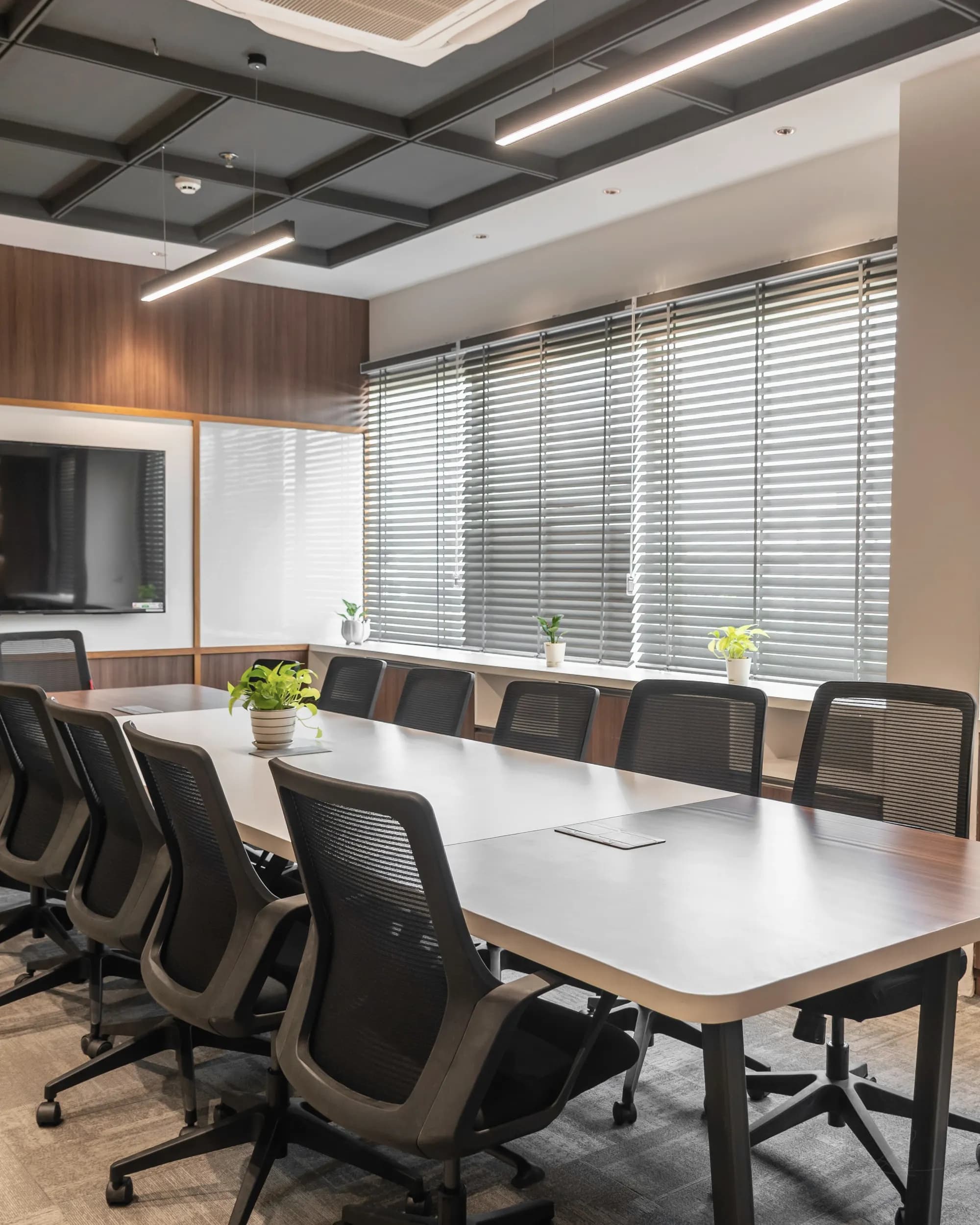 An empty boardroom with wood panelling and drawn blinds