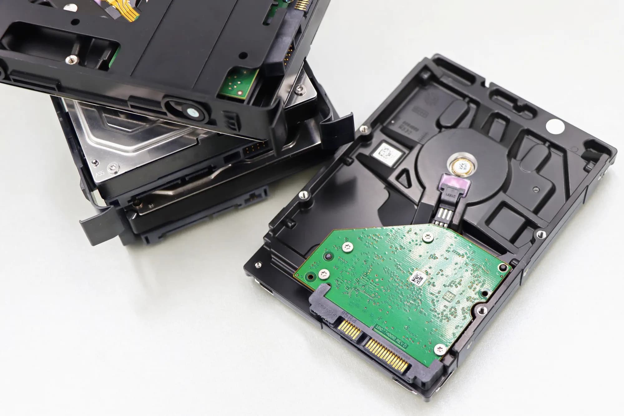 Opened hard disk drives laid out on a white bench